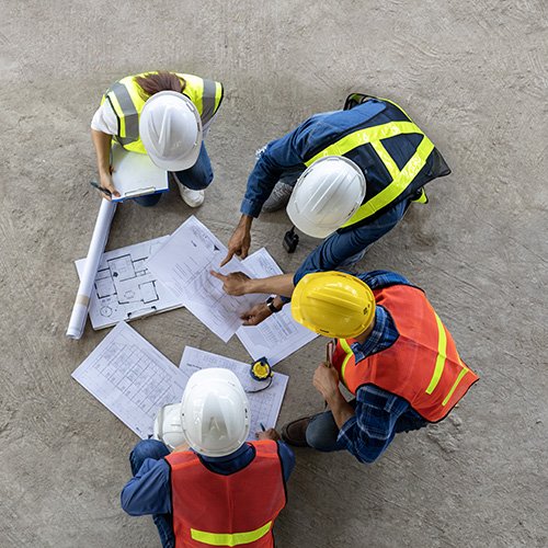 Builders on a site looking at maps