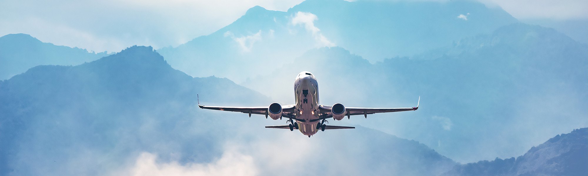 Airplane flying with mountains in the background