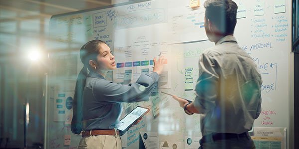 Two colleague looking at a white board