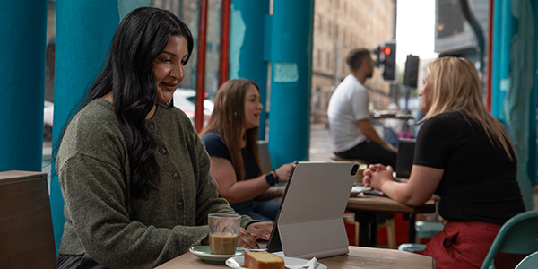 Woman on iPad reading in a cafe Woman on iPad reading in a cafe